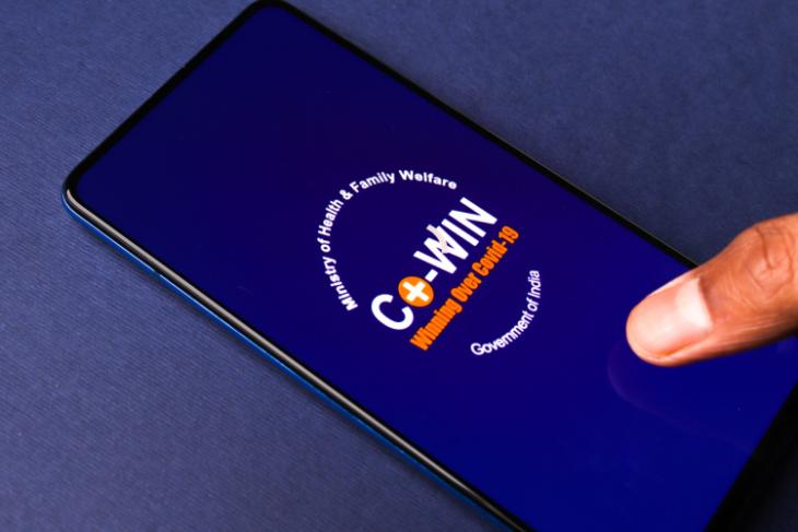 O aplicativo CoWIN aberto em um dispositivo móvel, colocado em um fundo azul
