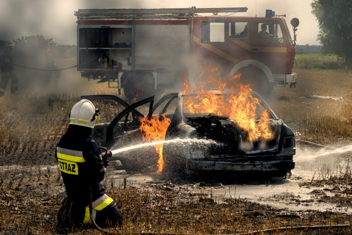 Bombeiro trabalhando em incêndio em carro elétrico
